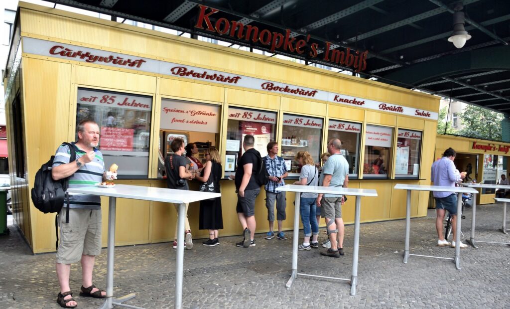 warten auf die Currywurst vor dem Konnopke's Imbiß in Berlin