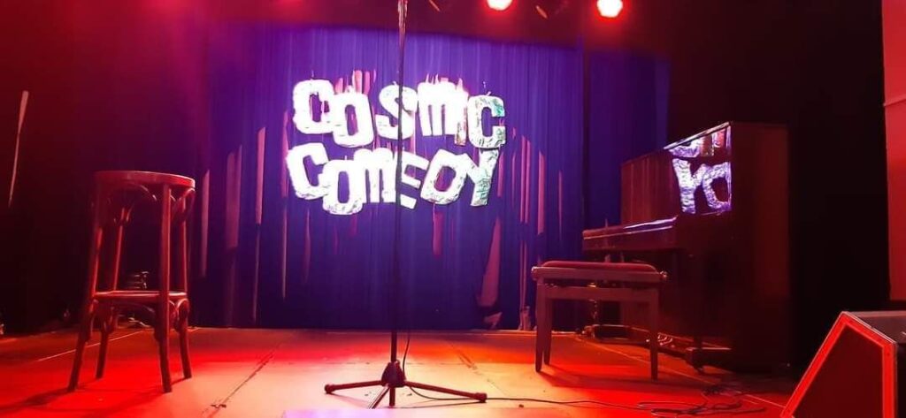 Vorbereiteter Bühnenbereich für Stand-up-Comedy-Auftritte bei Cosmic Comedy Berlin mit rotem Bühnenlicht.