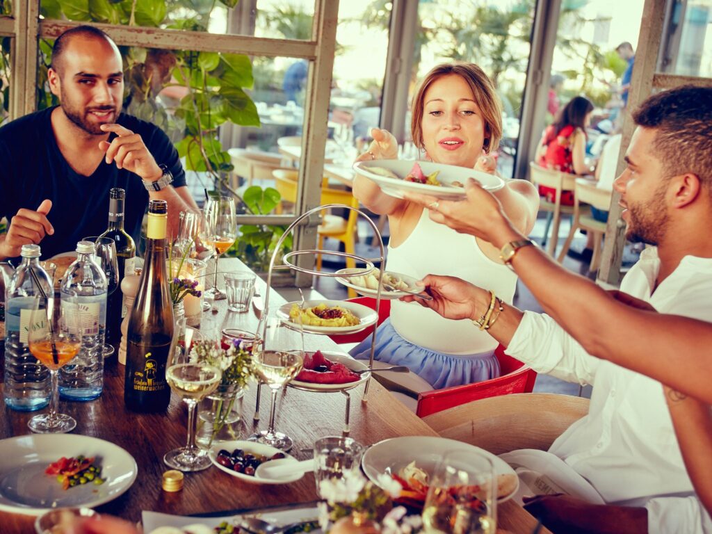 Friends share food at NENI, one of Berlin's most famous crazy restaurants with international cuisine.