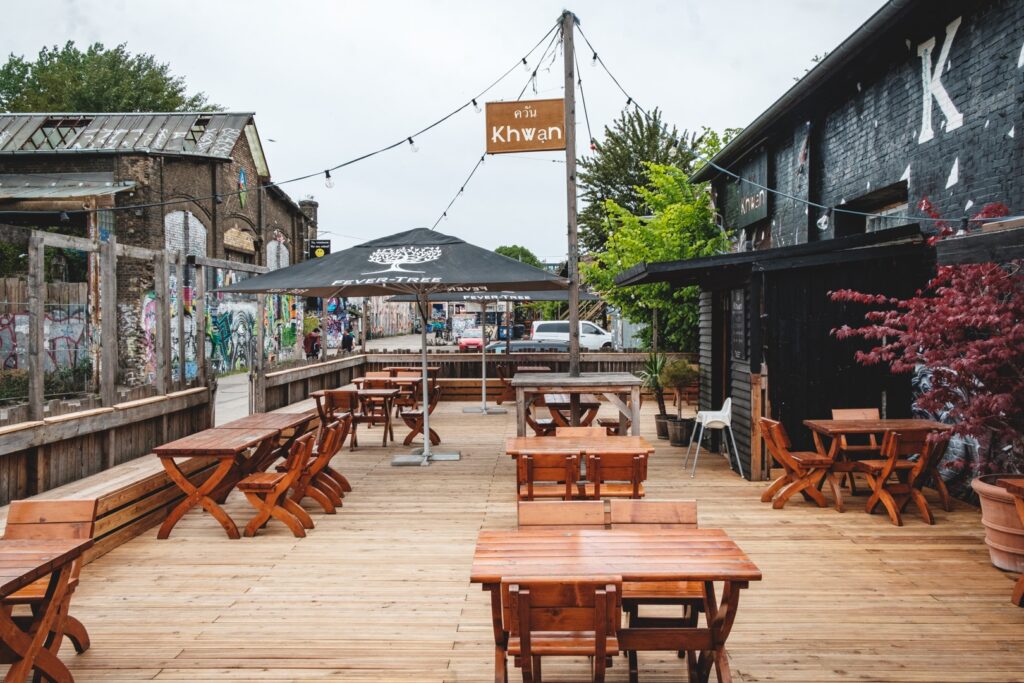 Außenbereich des Khwan – entspanntes BBQ-Restaurant Prenzlauer Berg Geheimtipp mit Holzmöbeln.